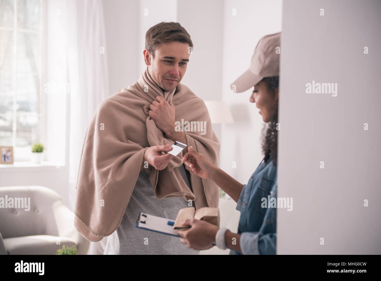Jeune homme malade de donner une carte de crédit pour le courrier Banque D'Images