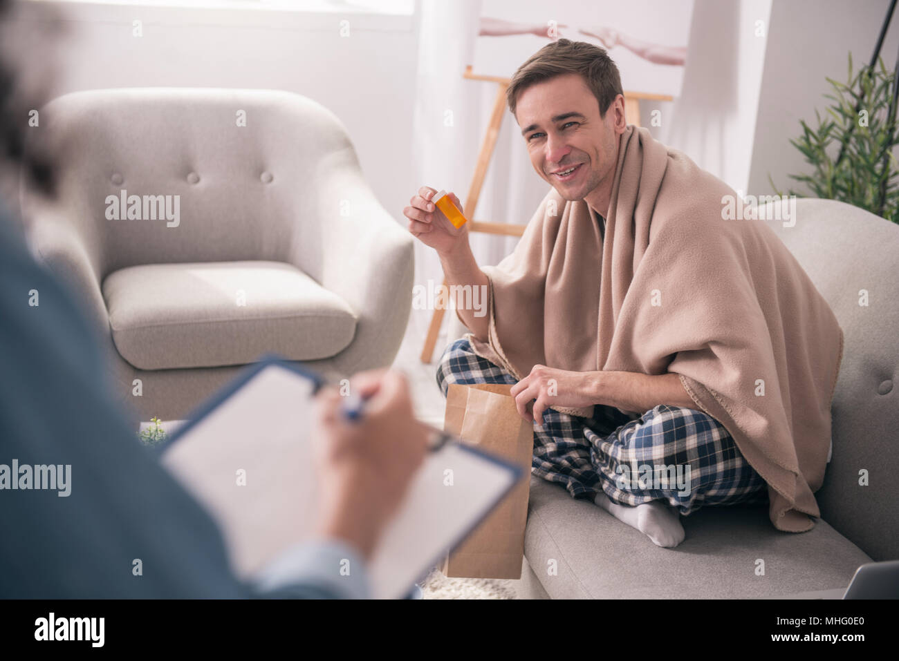 Un homme joyeux tenant son médicament Banque D'Images