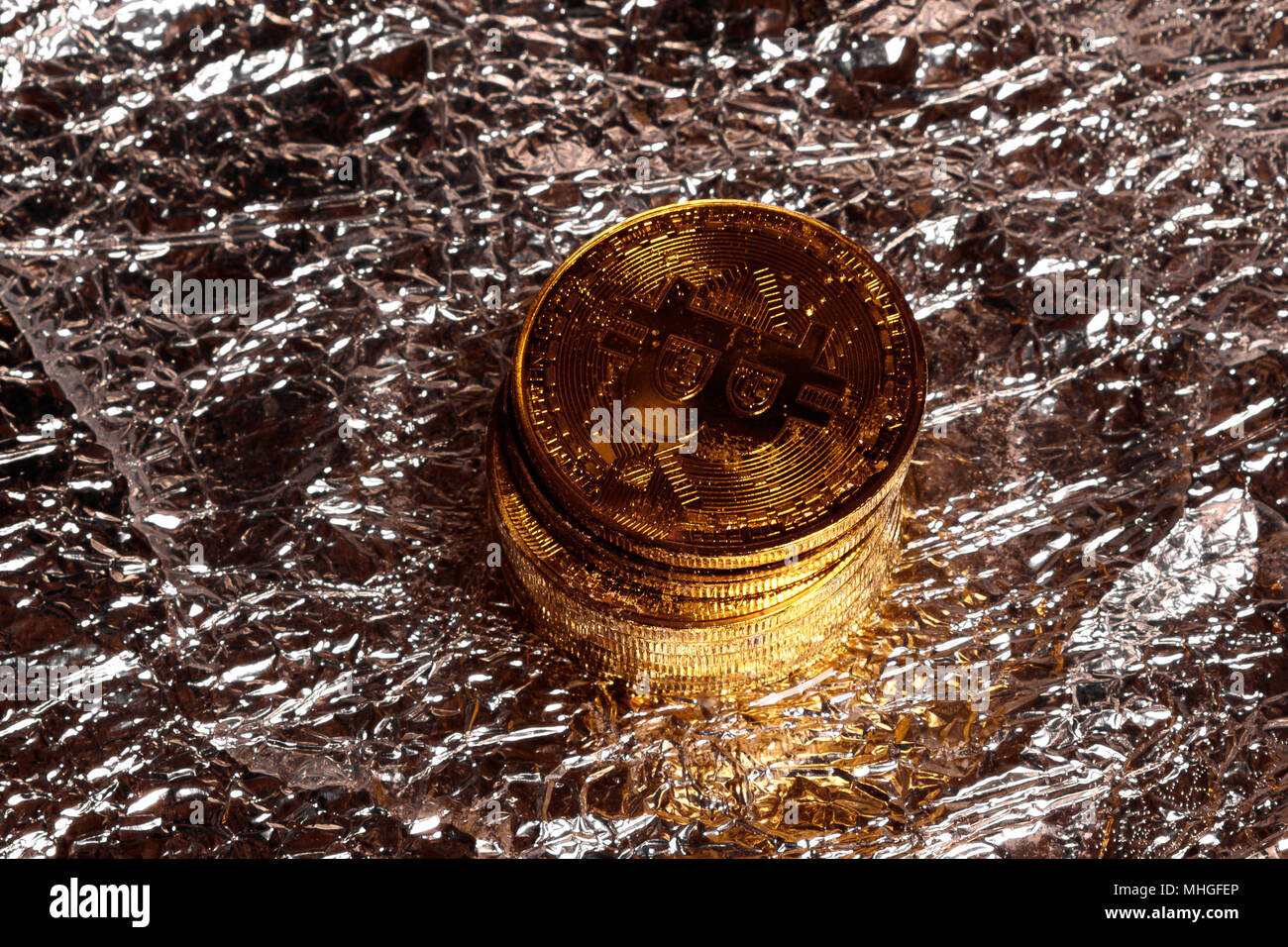 Pile de bitcoins physique d'or sur un fond d'aluminium Banque D'Images