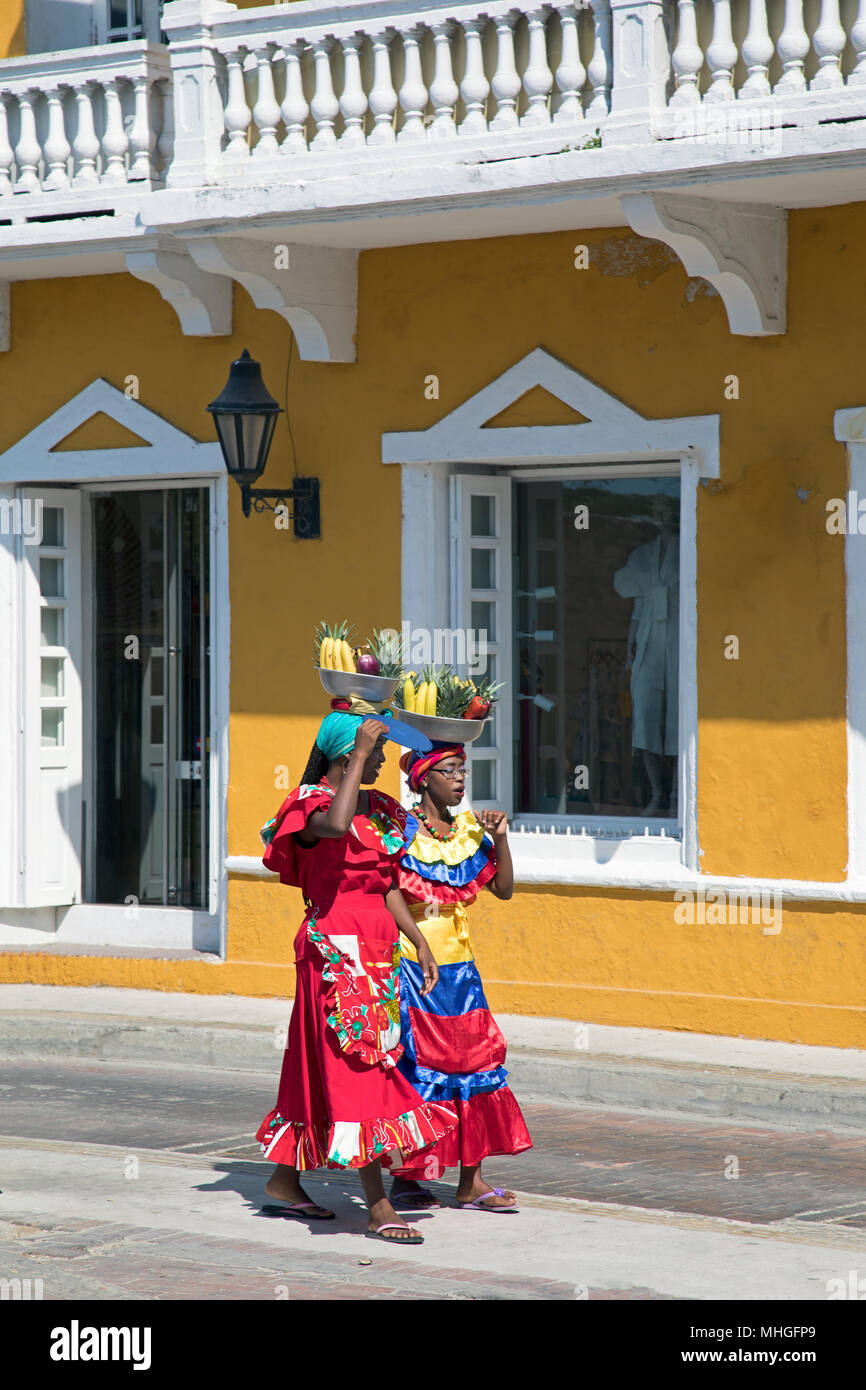 Deux femmes avec des paniers de fruits sur leur tête marcher dans une rue à Cartagena, Colombie. Banque D'Images