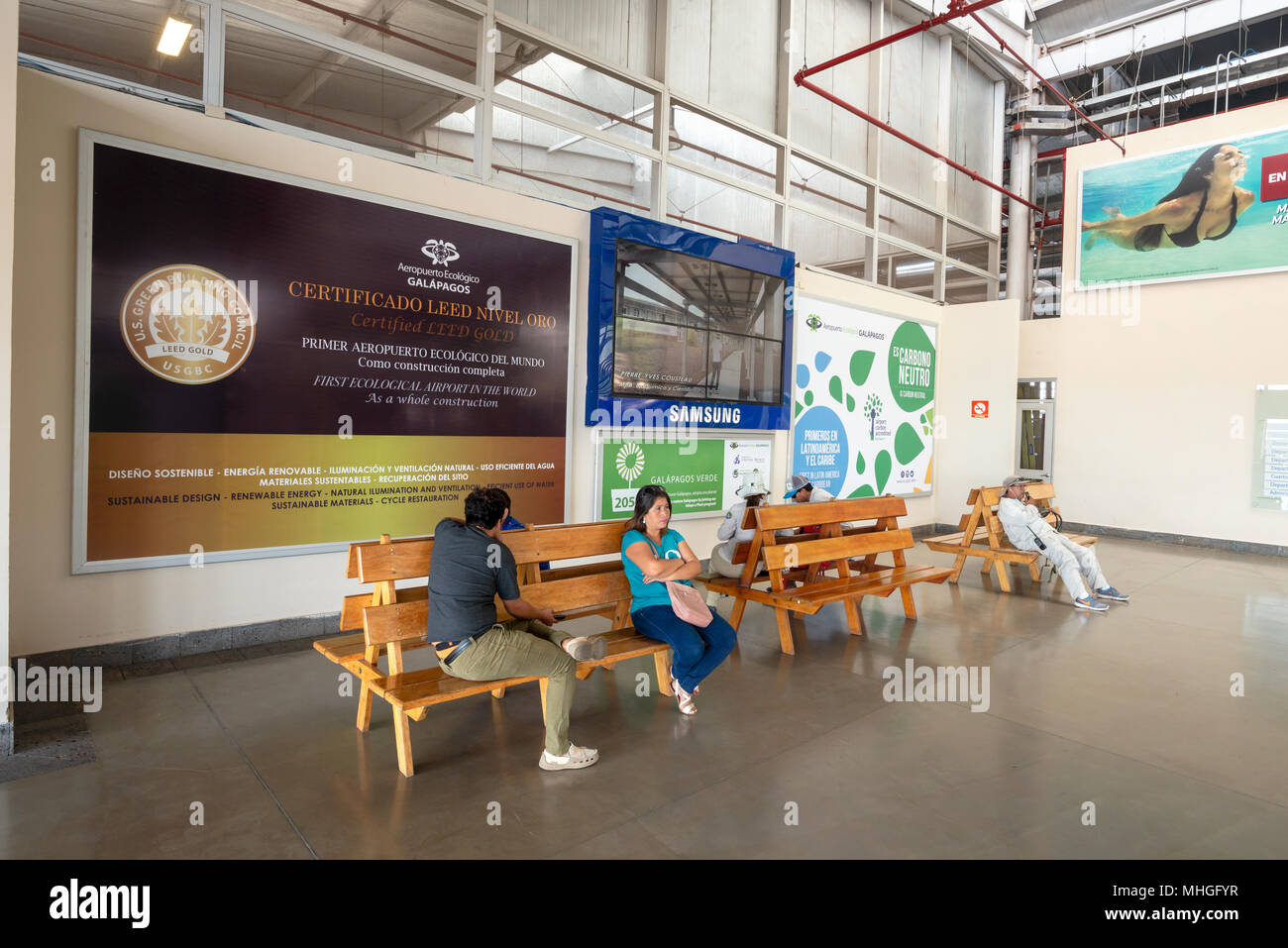 Les passagers qui attendent sur des bancs dans le terminal de l'aéroport de Baltra Seymour sur l'Île, Îles Galapagos, en Équateur. L'aéroport est certifié LEED Or. Banque D'Images