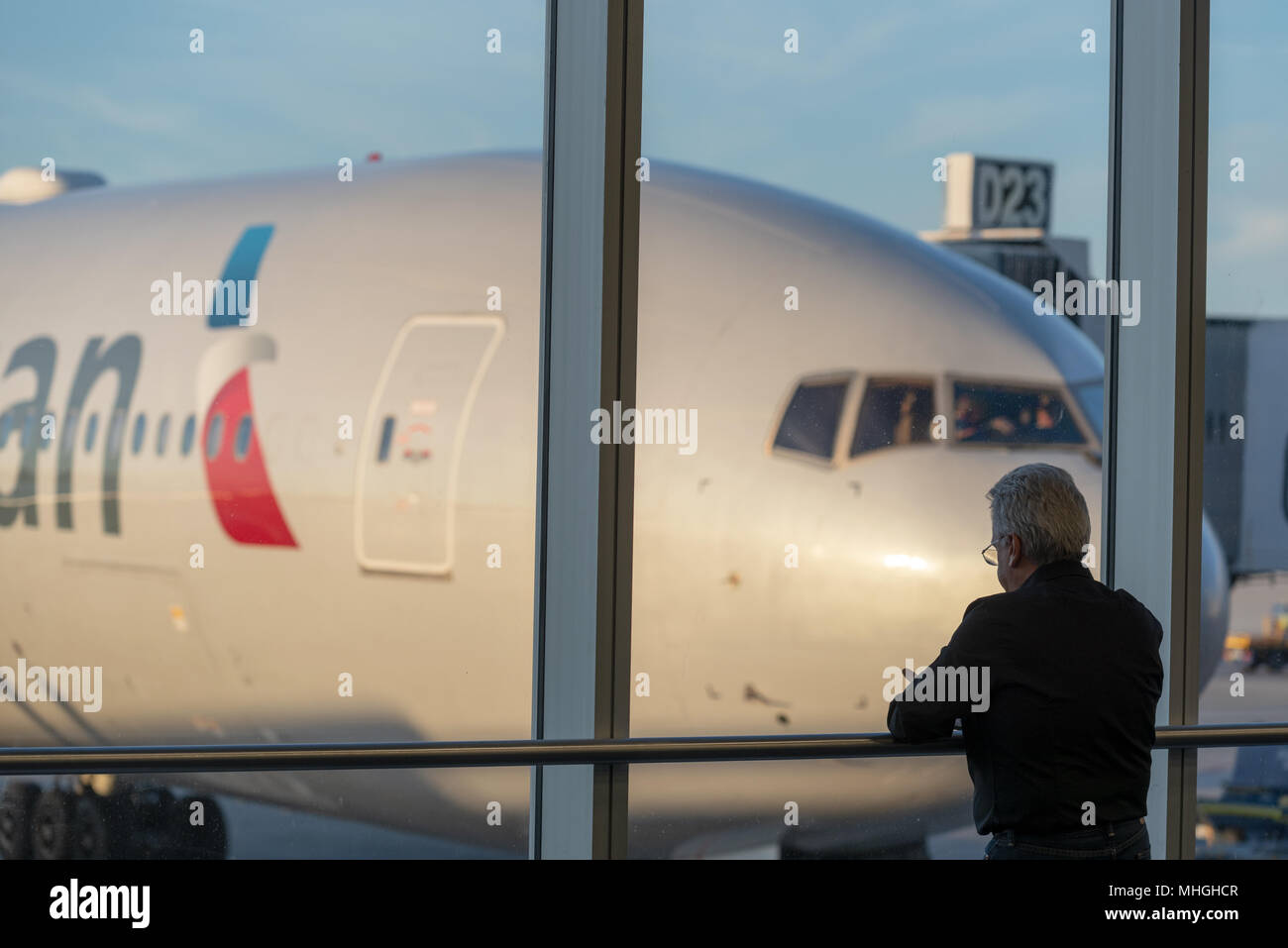 Passager à la fenêtre d'une porte dans l'Aéroport International de Miami à Miami, en Floride. Banque D'Images