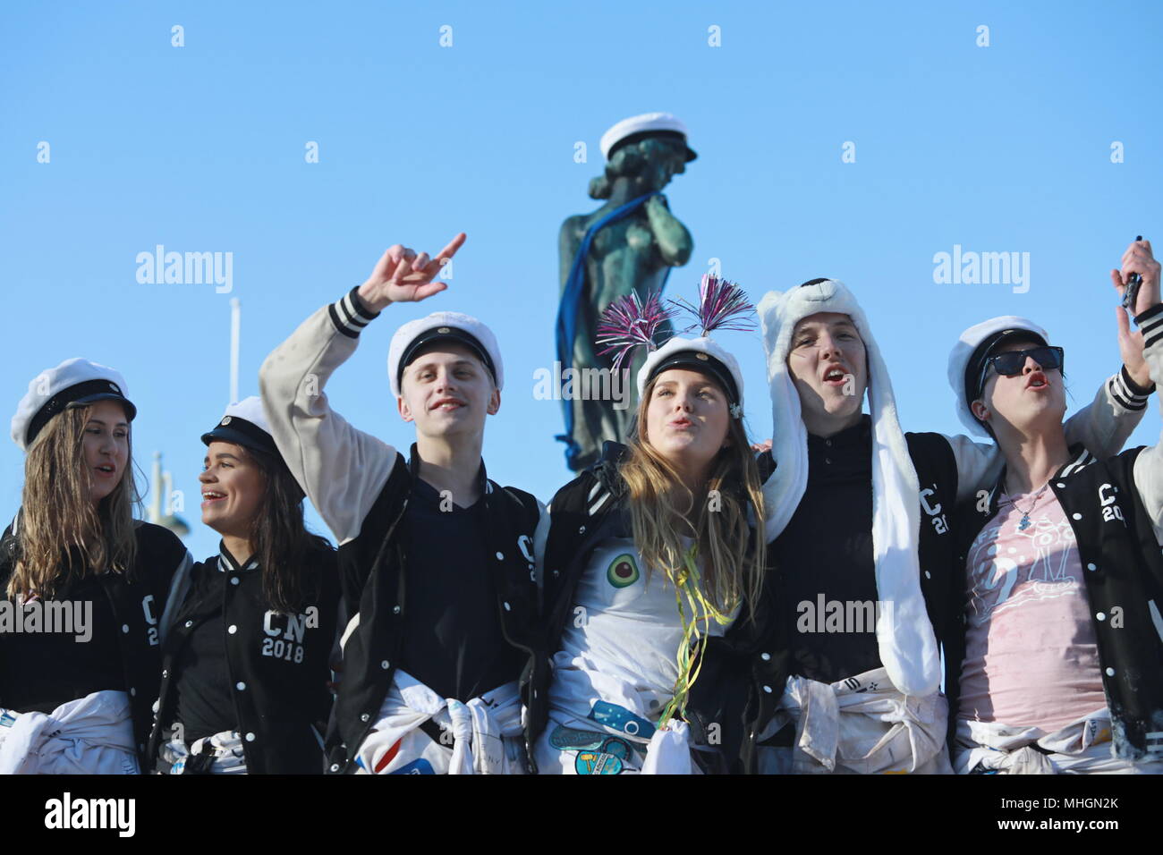 Helsinki, Finlande. Apr 30, 2018. Un groupe de fêtards chanter devant la statue de Havis Amanda après avoir été couronné d'un étudiant blanc cap à Helsinki, Finlande, le 30 avril 2018. Havis Amanda, un point de repère permanent statue en bronze dans le sud du front de mer de Helsinki, est magnifiquement couronnée d'un étudiant blanc cap à la veille du premier mai de chaque année. Crédit : Li Jizhi/Xinhua/Alamy Live News Banque D'Images