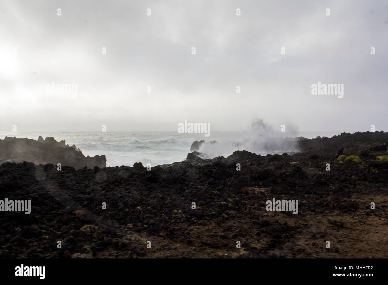 Vagues se briser contre les roches noires Banque D'Images