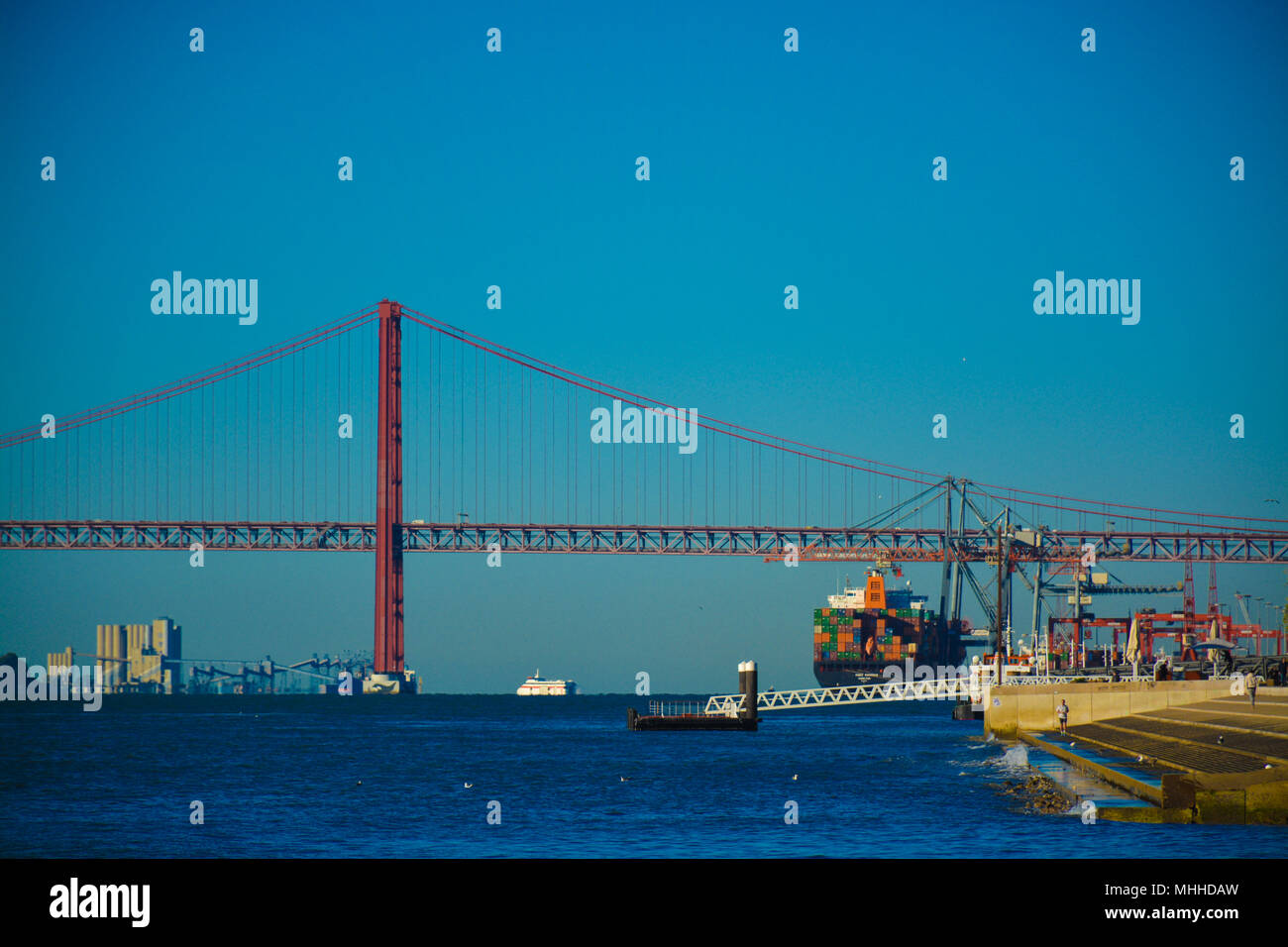 Pont de Lisbonne et grand navire avec des conteneurs. Banque D'Images
