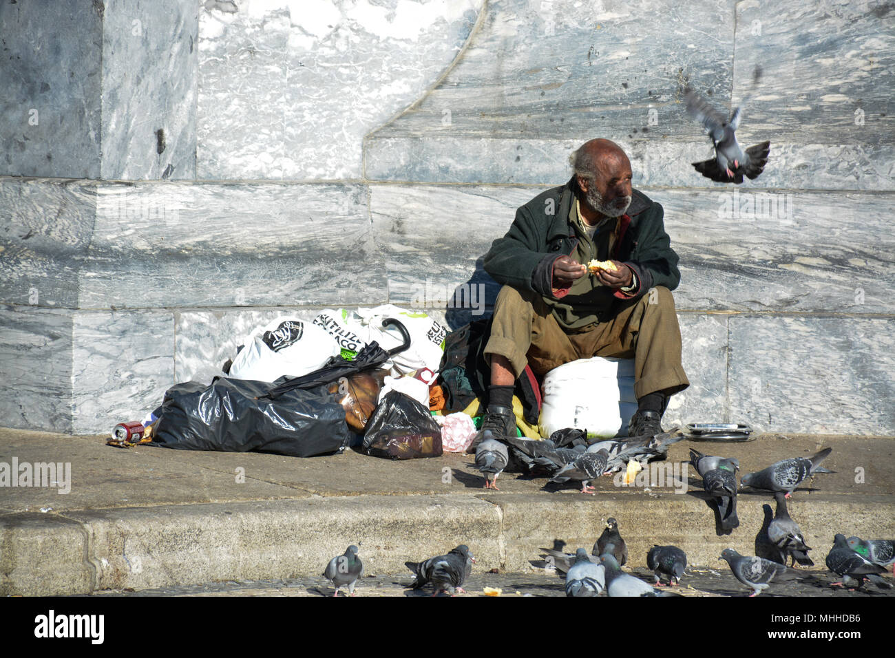 Vieil homme nourrir les pigeons à Lisbonne, capitale du Portugal. Banque D'Images