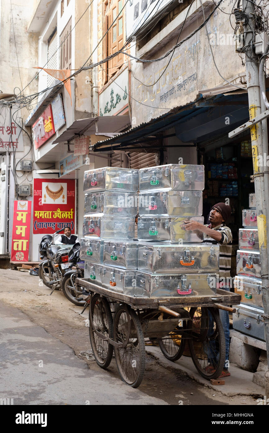 Man loading caisses en métal sur un chariot. . Udaipur, également connu comme la ville des lacs, la Venise de l'Orient, est la capitale historique du royaume de Mewar, Rajasthan. Banque D'Images