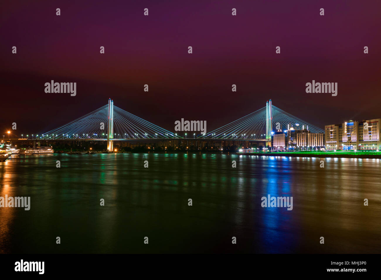 Nuit lumières de la ville se reflètent dans l'eau avec une vue sur le pont. Crimson night sky Saint Petersburg Banque D'Images