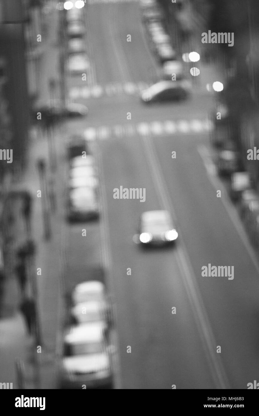 Rue de la ville avec des voitures en stationnement et circulation defocused. Scène d'intrigue Banque D'Images