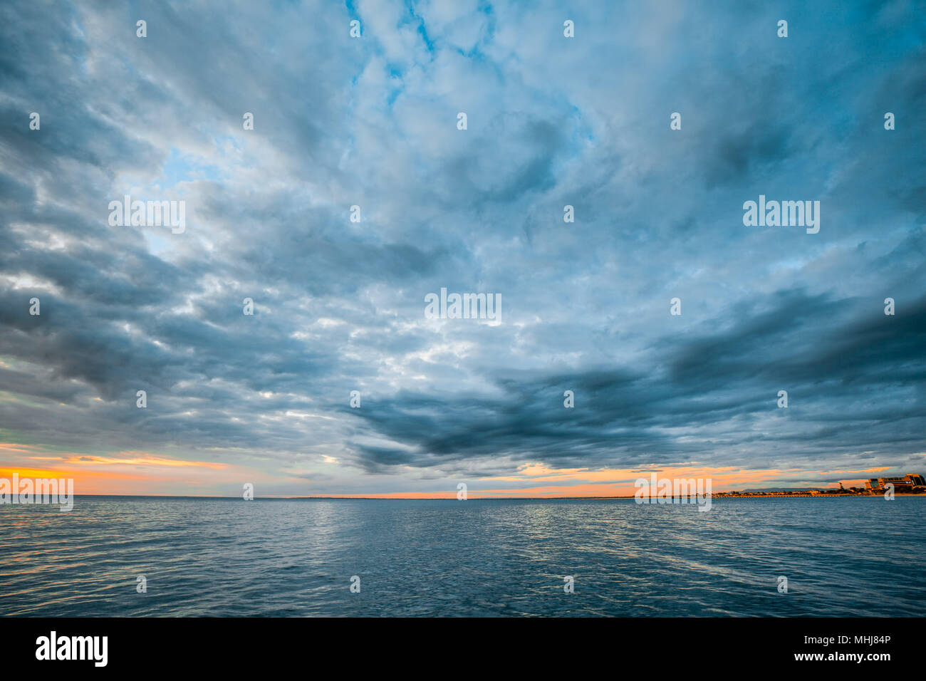 Les nuages orageux au-dessus de l'eau de l'océan calme au coucher du soleil seascape Banque D'Images