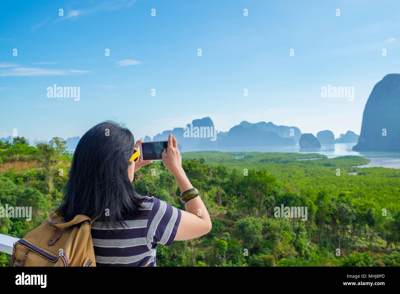 Jeune voyageur woman backpacker utiliser mobile phone prendre une photo de la belle nature du lever du soleil en haut de la liberté sur la montagne,concept wanderlust Khao,S Banque D'Images