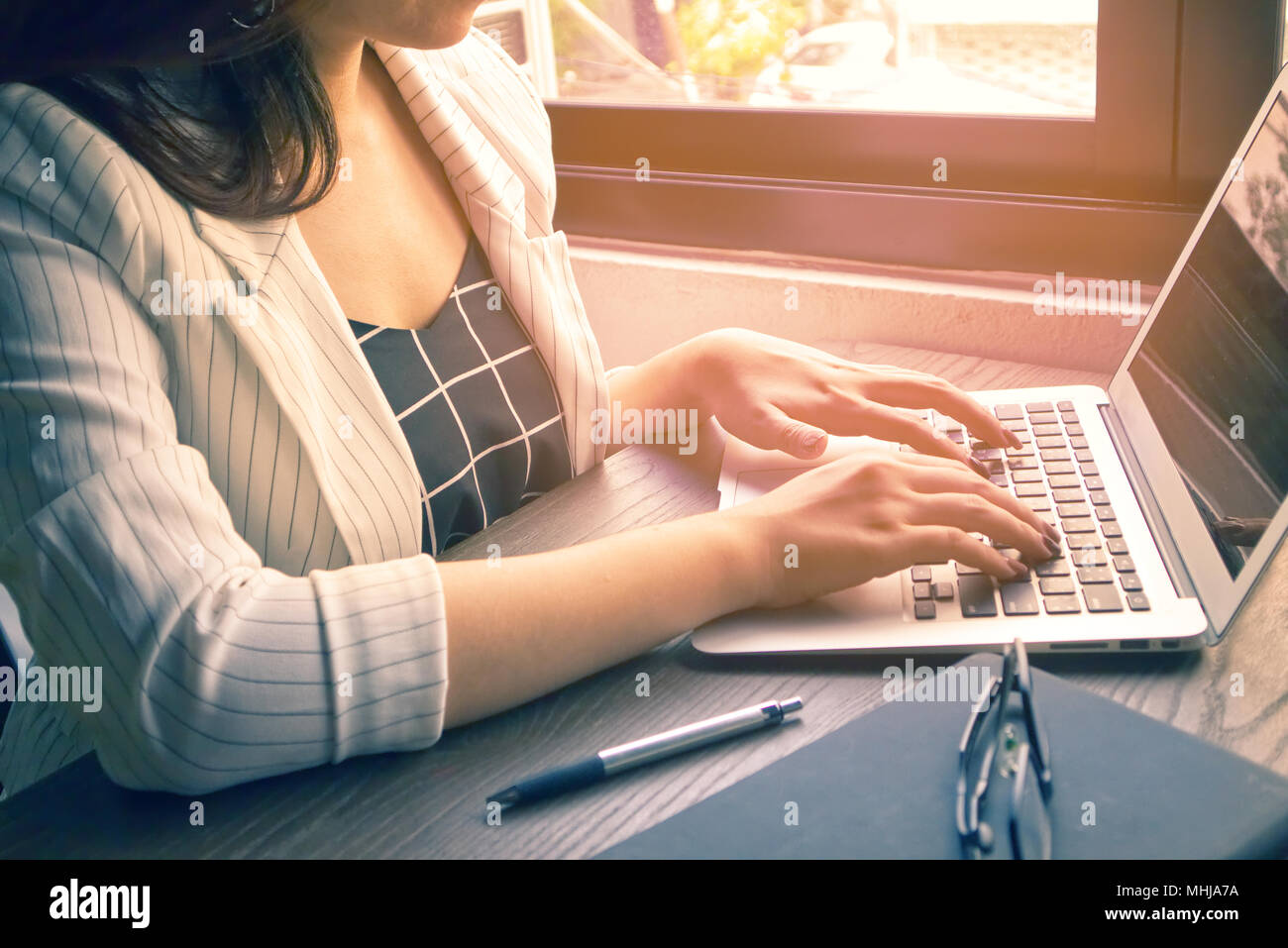 Les femmes d'affaires et sur les ordinateurs portables de type memo stylo et livre ont et le verre sur la table en bois Banque D'Images