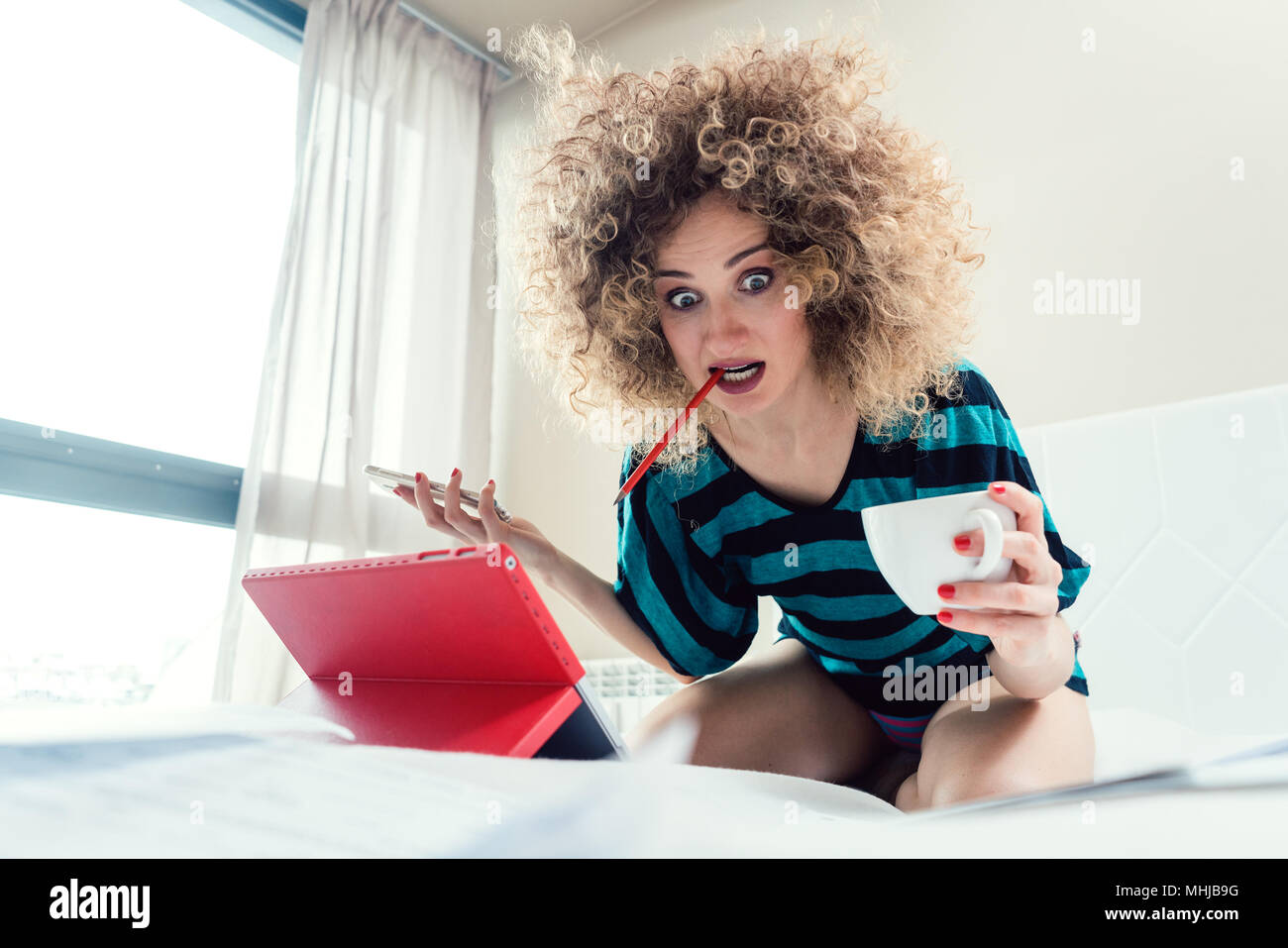 Femme sur son lit d'étudiant pour l'examen d'apprentissage dans la panique Banque D'Images