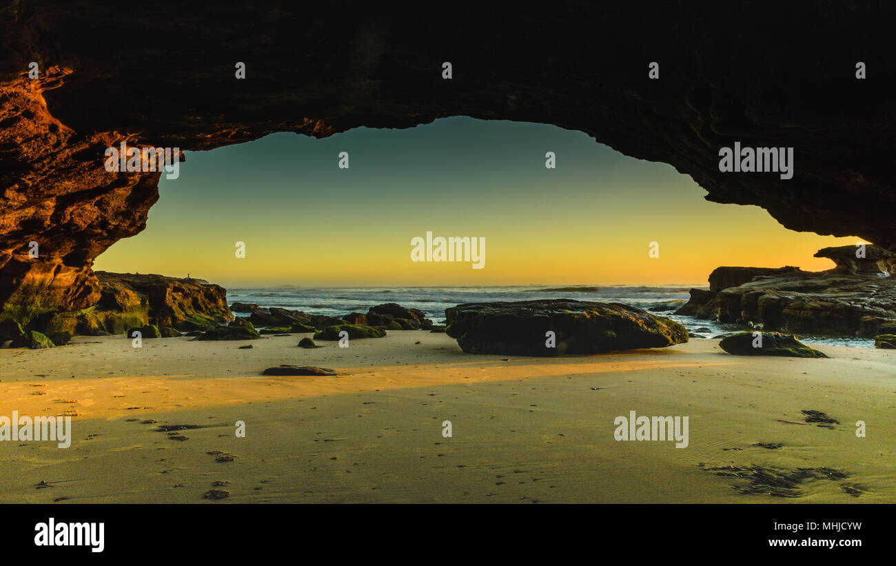 Lever du soleil paysage marin depuis une grotte - Capturer le lever du soleil sur la plage des Grottes de la péninsule de Swansea, Central Coast, NSW, Australie. Banque D'Images