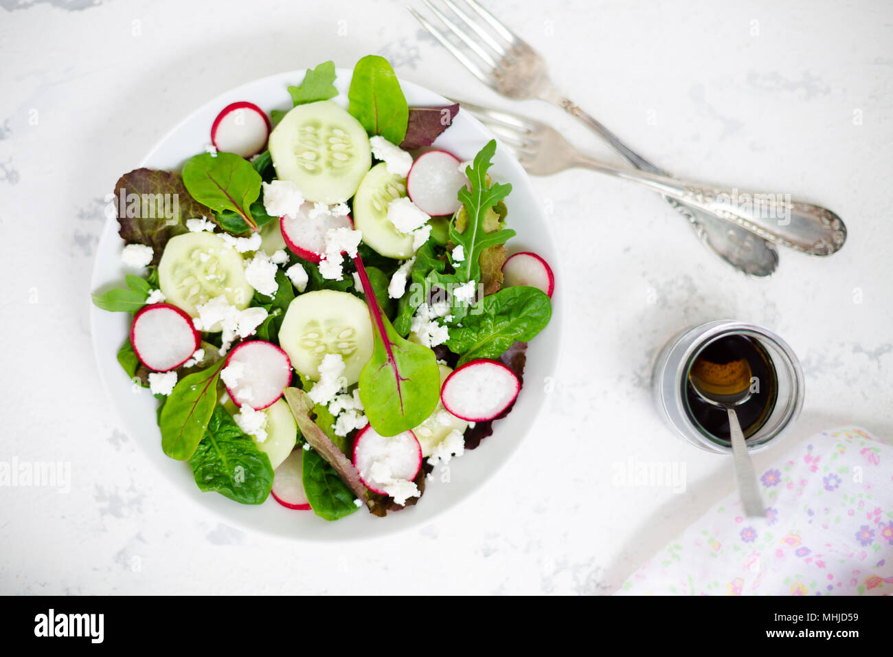 Salade Mixte avec bébé feuilles de laitue rouge, tatsoi, roquette, red chard, radis, concombre et fromage feta à l'huile d'olive et vinaigrette au vinaigre balsamique Banque D'Images