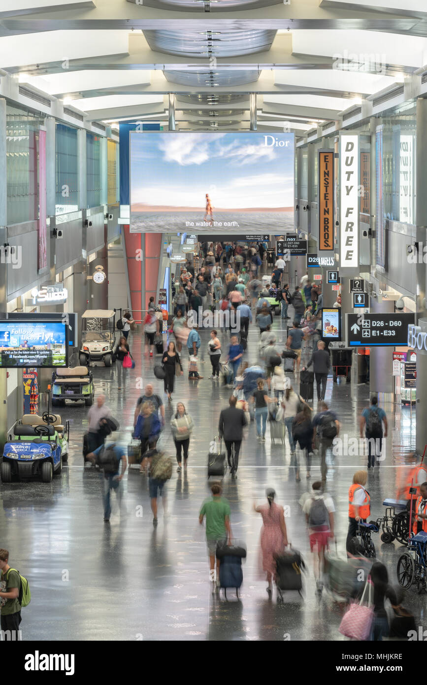 Les voyageurs à la motion en Hall D'Aéroport International de Miami, à Miami, en Floride. Banque D'Images