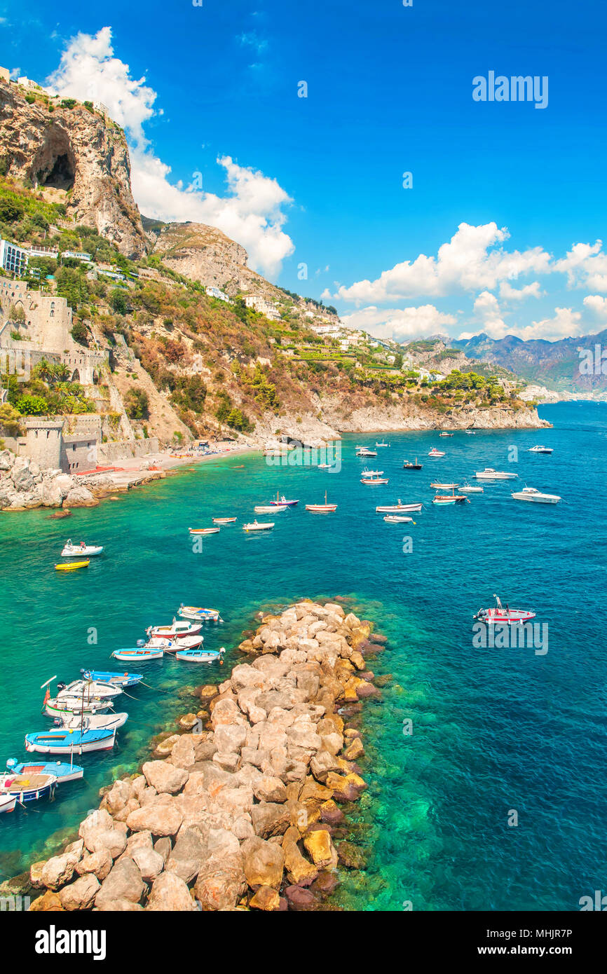 Petit village de pêcheurs avec bateaux amarrés au quai et des eaux bleu turquoise entourée de montagnes aux beaux jours de l'été, la Côte d'Amalfi, Salerne, Campanie Banque D'Images