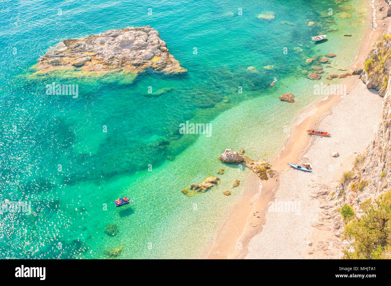Vue aérienne de plusieurs personnes en appui sur la plage isolée avec des eaux bleu turquoise sur jour d'été chaud et ensoleillé Banque D'Images