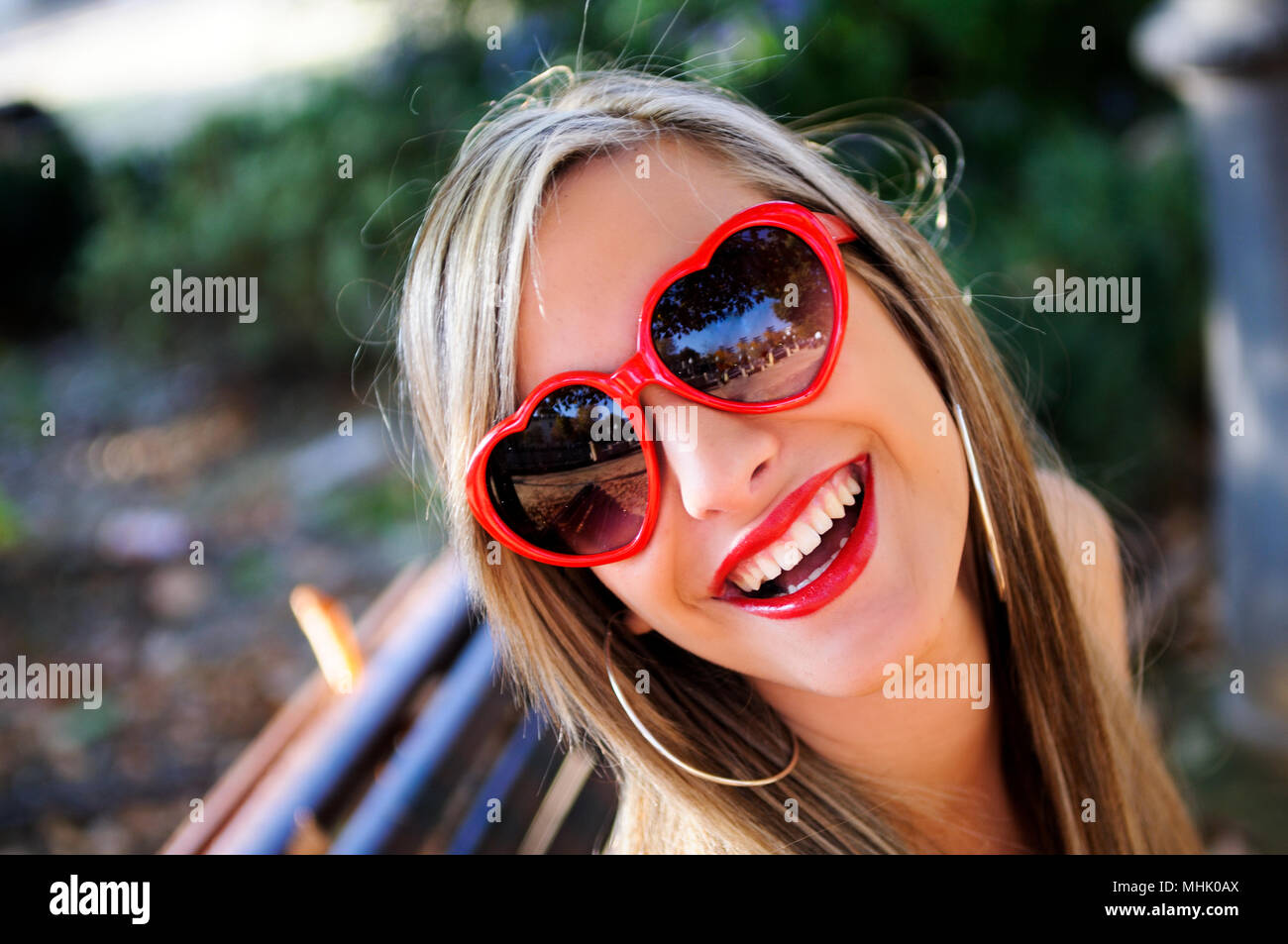 Funny Girl avec coeur rouge lunettes dans un parc Banque D'Images