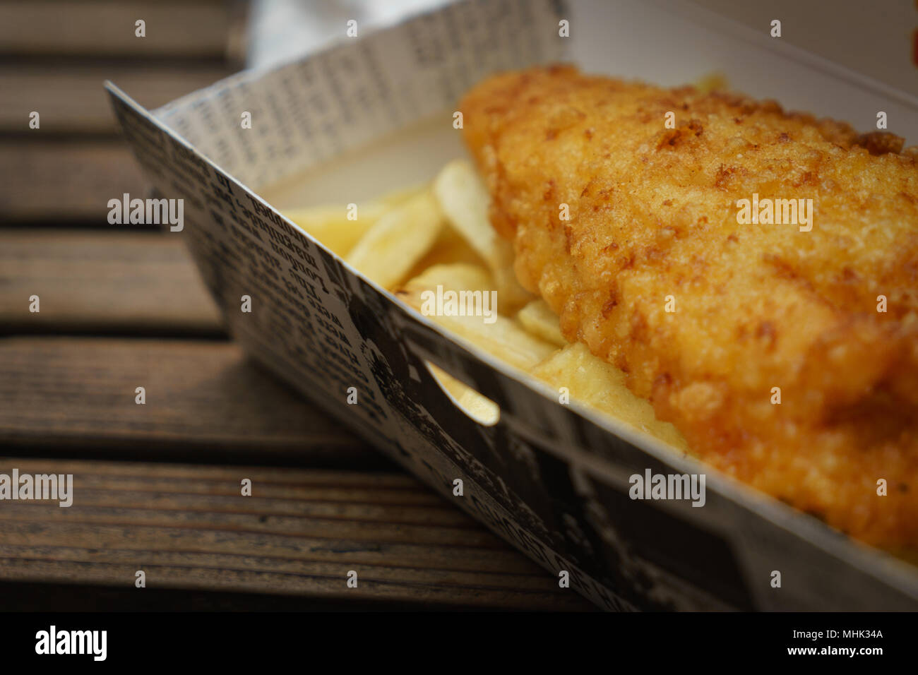 La morue et battues frites traditionnelles plaquettes dans une boîte sur une table en bois. Le format paysage. Banque D'Images