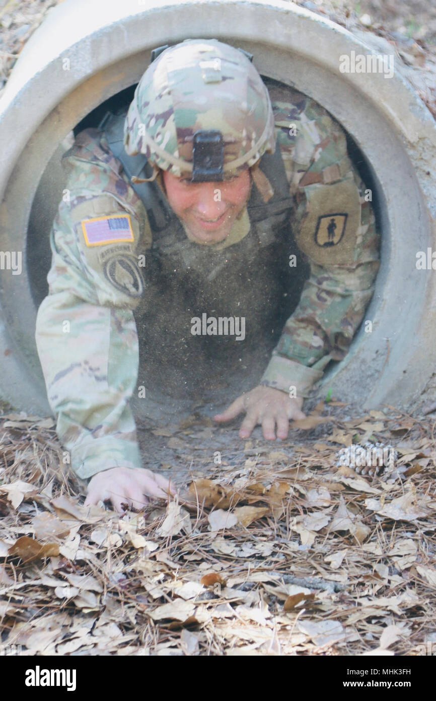 Fort Stewart, Géorgie, le 7 mars 2015 - Georgia National garde le s.. Kevin D'Aversa du 78e commandement de troupes basé à Ellenwood, Ga., rampe d'un tunnel comme la poussière vole autour de lui pendant le déplacement individuel sur l'événement de trois jours le meilleur guerrier de la concurrence. Banque D'Images