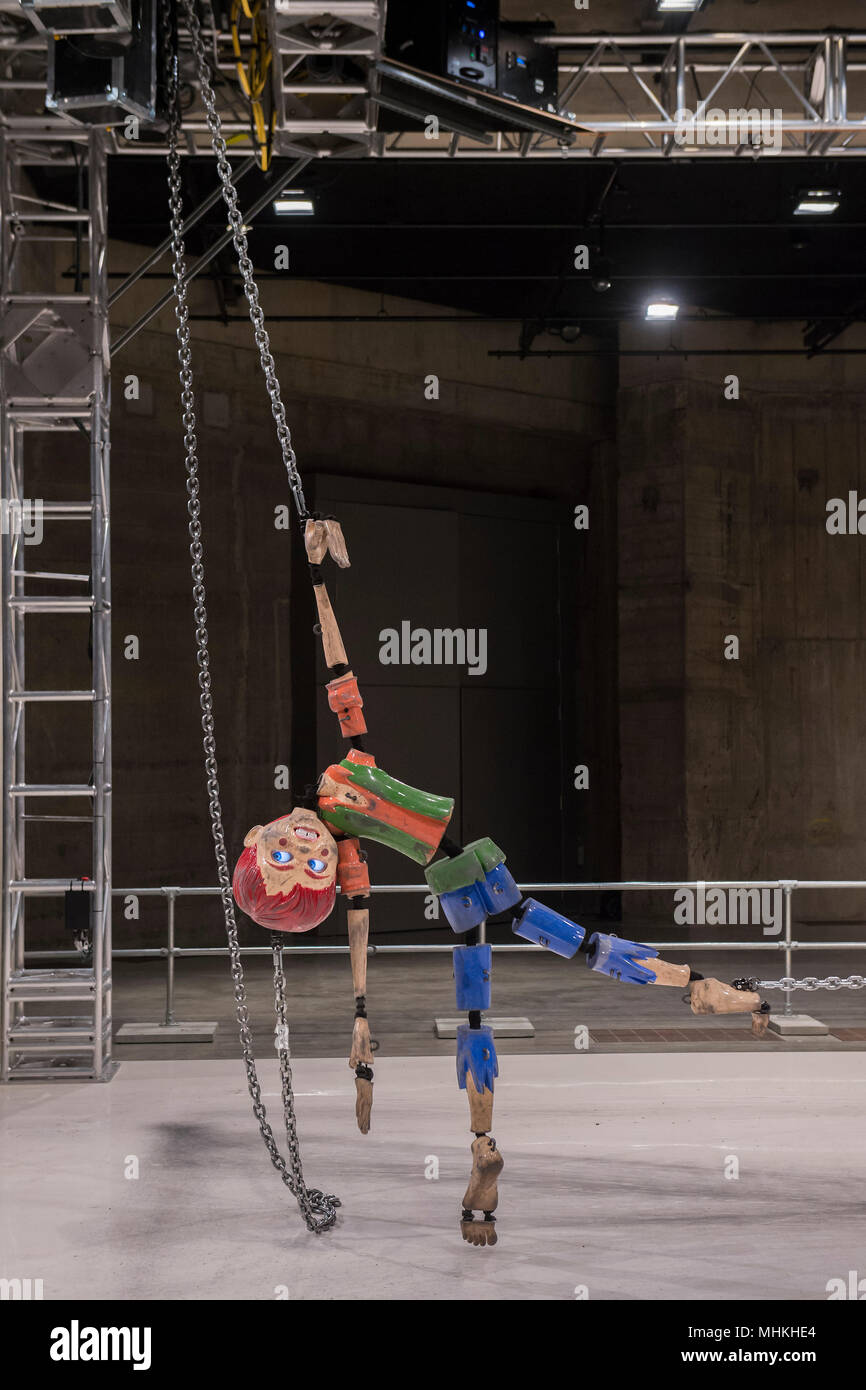 Londres, Royaume-Uni. 2e mai 2018. Jordan Wolfson Couleur de la sculpture, une installation d'animatronic à grande échelle dans les réservoirs à la Tate Modern. Il dispose d''une marionnette menaçant plus de 7 pieds de haut, qui est élevé, tiré, glisser au sol par des chaînes mécanisées attachés à chaque membre. La figure s'appuie sur différentes représentations de l'enfance à partir de la pop culture américaine. Équipés d'écrans numériques pour les yeux, la marionnette de capteur permet de fixer les spectateurs avec son regard fixe qu'il bouche un sibyllin Liste des déclarations menaçantes. Crédit : Guy Bell/Alamy Live News Banque D'Images