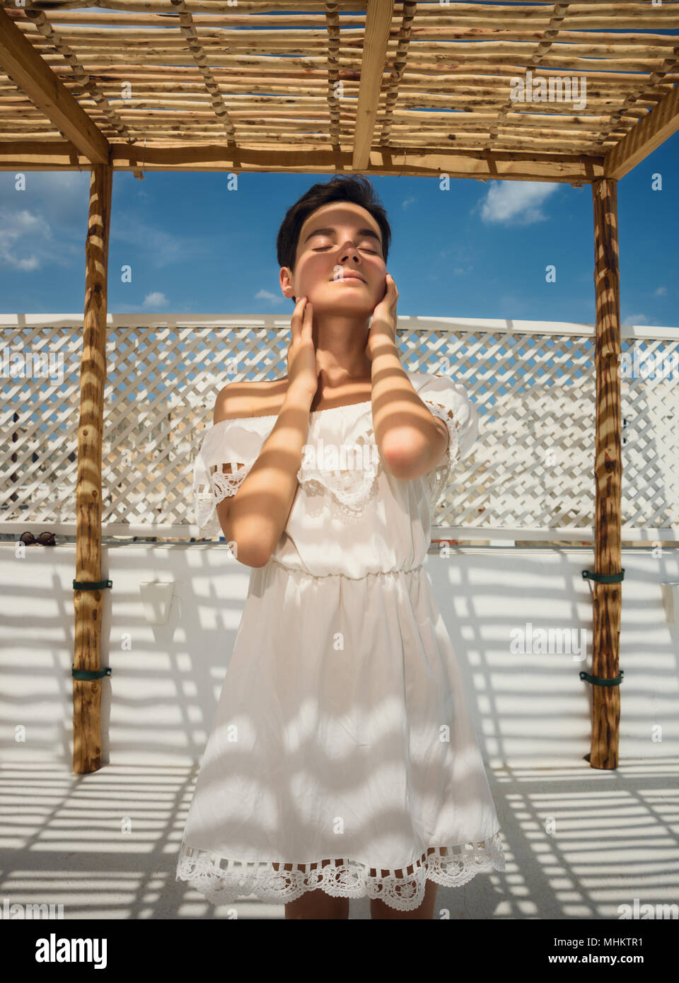 Une jeune fille en robe blanche sur la terrasse. Face à l'ombre. Ombre à  rayures. Repos, vacances, voyage. La Tunisie Photo Stock - Alamy