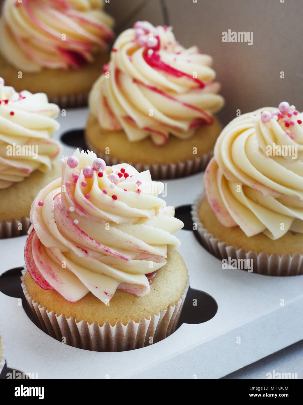Cupcakes vanille délicate avec la crème dans la boîte sur un fond blanc Banque D'Images