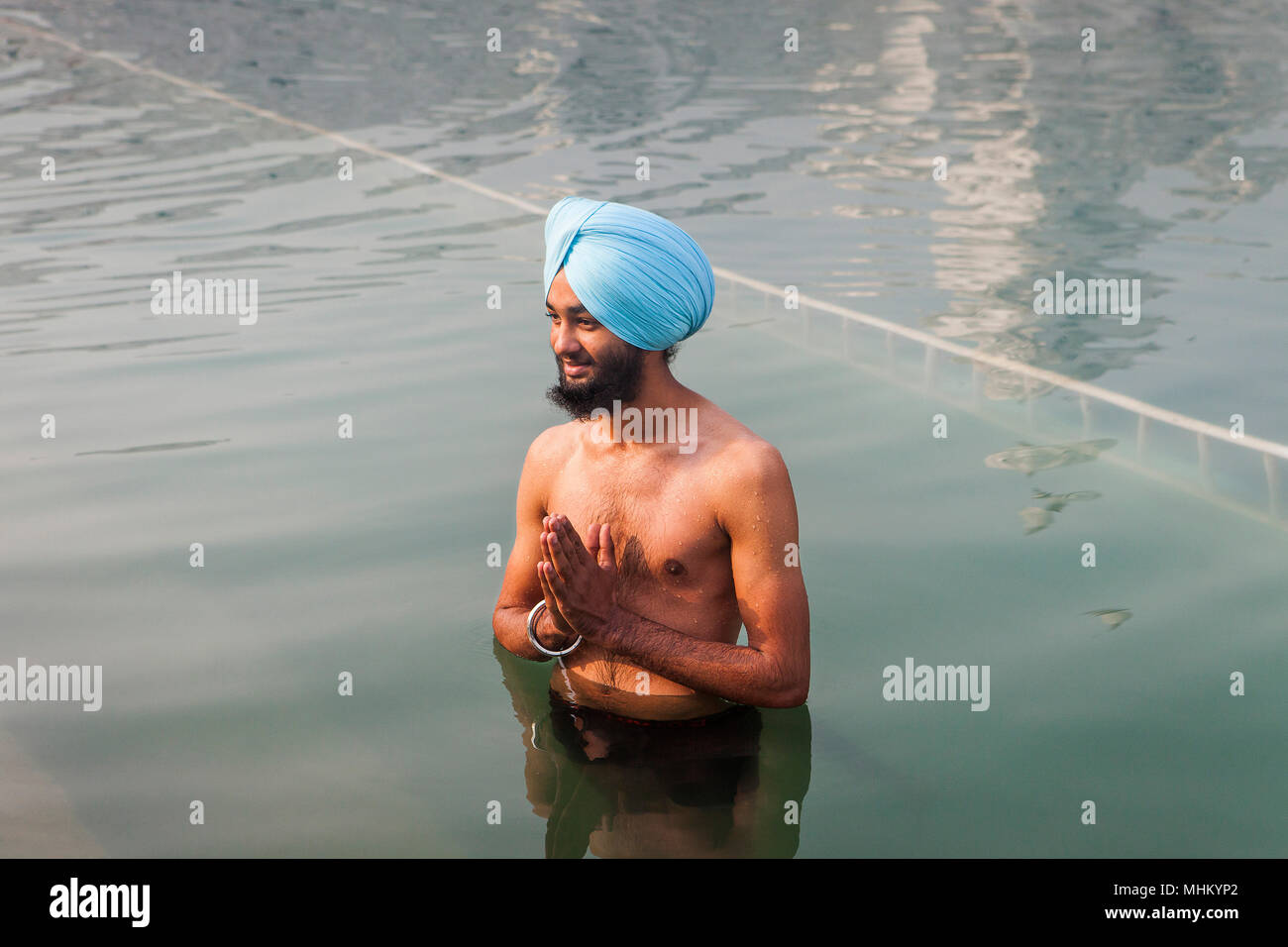 Pilgrim se baigner dans le bassin sacré Amrit Sarovar, Golden Temple, Amritsar, Punjab, India Banque D'Images