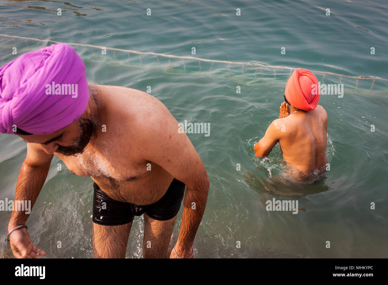 Les pèlerins se baigner dans le bassin sacré Amrit Sarovar, Golden Temple, Amritsar, Punjab, India Banque D'Images