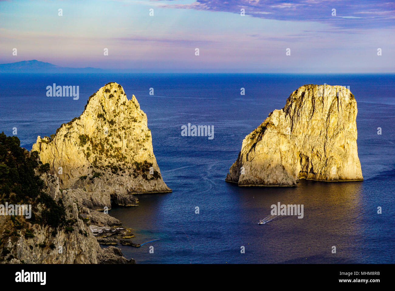 Soleil contre I Faraglioni de île de Capri dans la baie de Naples, Campanie, Italie Banque D'Images