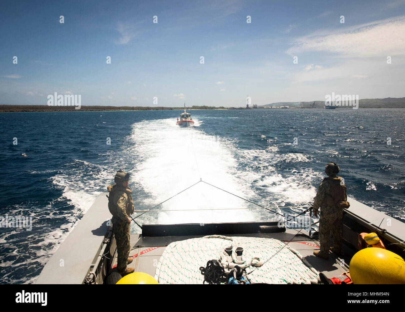 Les marins affectés à l'Escadron fluviales côtières (CRS) 4, Det. Guam regarder leur bateau de patrouille Mark VI remorque une embarcation à moteur de 47 pieds affectés à la Garde côtière des États-Unis Guam Secteur pendant un exercice de remorquage à l'Apra Harbour, de Guam, le 28 mars 2018. CRS-4, Det. Guam est attribué au commandant, Force opérationnelle 75, la task force expéditionnaire principale responsable de la planification et l'exécution des opérations fluviales côtières, des explosifs et munitions, d'ingénierie et de construction, plongée sous-marine et de construction dans la 7e flotte américaine zone d'opérations. (U.S. Caméra de combat de la marine Banque D'Images