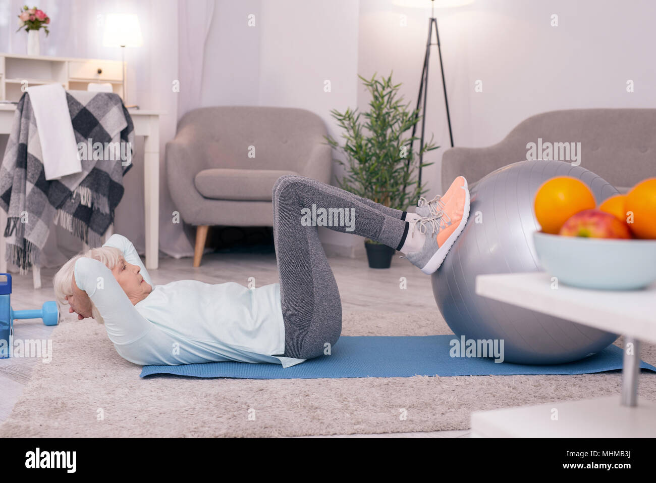 Personnes âgées Slim woman doing sit-ups avec l'aide du yoga ball Banque D'Images