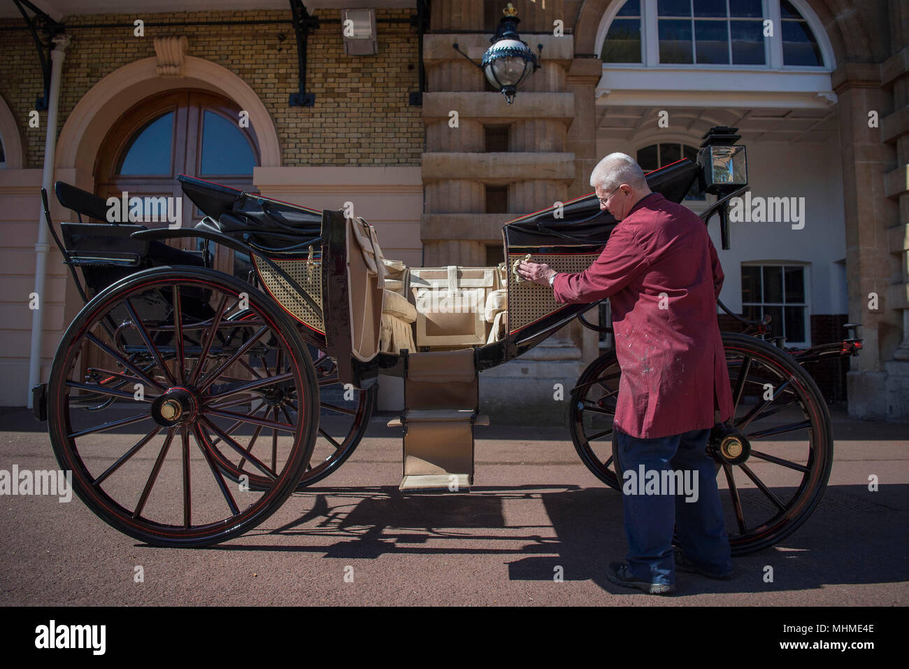 Martin Oates, restaurateur du chariot, polit l'Ascot Landau, qui sera utilisé dans le cas de temps sec au mariage du prince Harry et Meghan Markle, au Royal Mews à Buckingham Palace, Londres. Banque D'Images