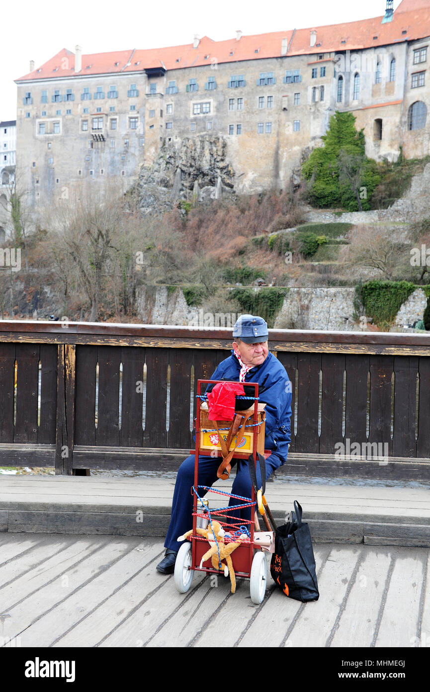 Un musicien ambulant à jouer de la musique sur l'un des ponts de Cesky Krumlov. Dans l'arrière-plan, le château de ville peut être vu. Banque D'Images