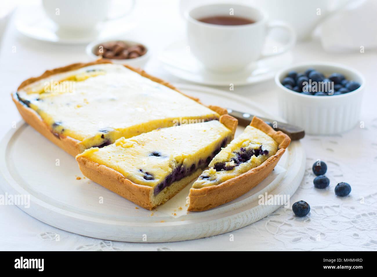 L'heure du thé. Blueberry Cheesecake maison, tasses de thé, les noix et berry sur nappe blanche Banque D'Images