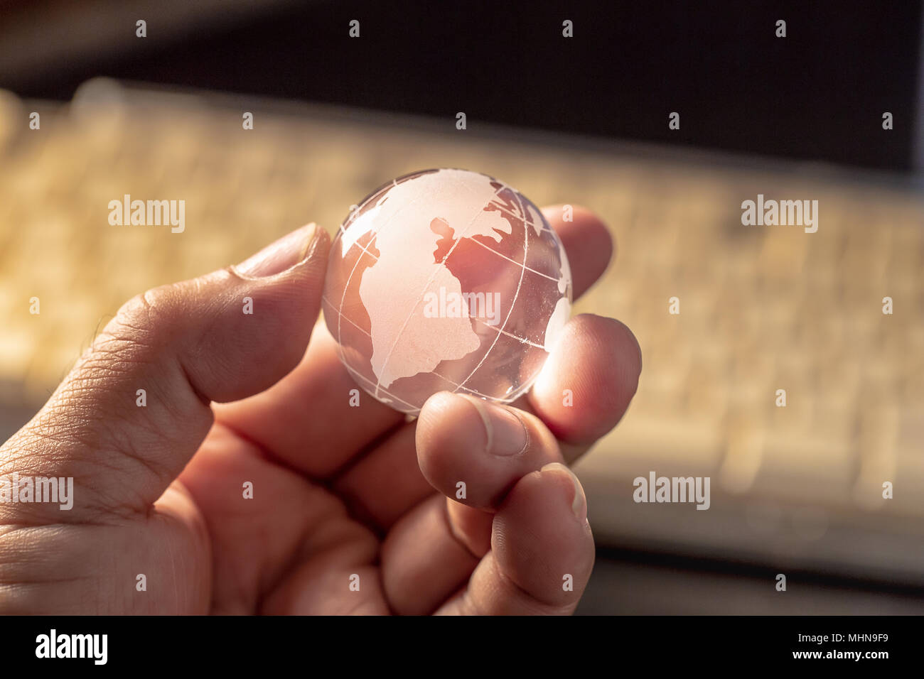 Globe en verre sur fond sombre dans la main. Banque D'Images