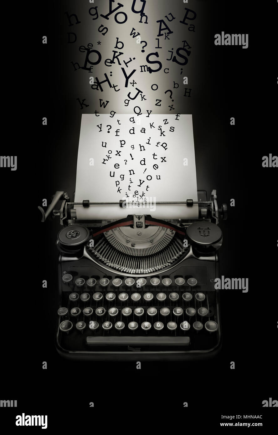 Fantasy composition de lettres à tomber sur machine à écrire plus de page blanche. Fond noir et l'effet de lumière sur la page blanche. Banque D'Images