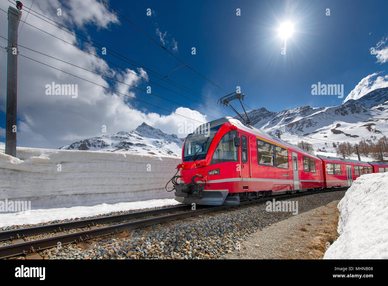 Swiss Mountain train Bernina Express traversé Alpes avec mur de neige. Banque D'Images