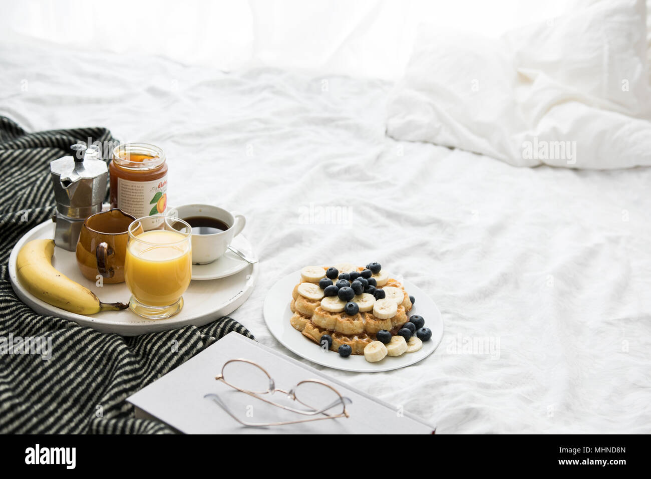 Scène de petit-déjeuner confortable au lit avec gaufres sur un week-end ensoleillé Banque D'Images