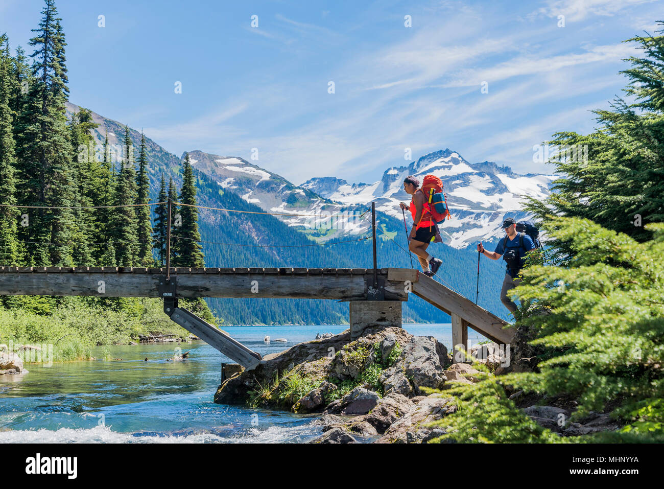 Backpackers crossing bridge, Garibaldi Lake, parc provincial Garibaldi, British Columbia, Canada Banque D'Images