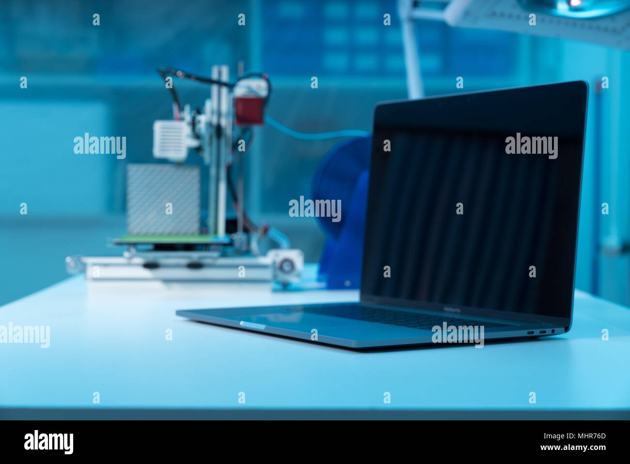 Ordinateur et imprimante 3d sur table en design industriel lab Banque D'Images