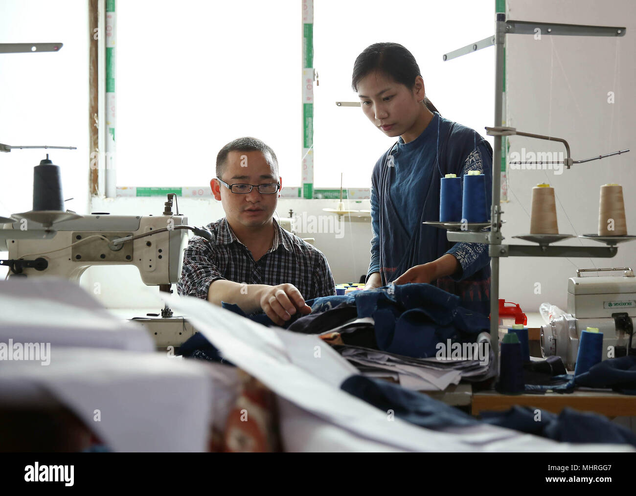 Danzhai, province du Guizhou en Chine. 2 mai, 2018. Zhang Yiping (R) traite de la production de vêtements batik avec son collègue de Danzhai County, au sud-ouest de la province du Guizhou, en Chine, le 2 mai 2018. Obsédé par la culture batik depuis un enfant, Zhang Yiping, une jeune femme née en 1993, a créé sa propre entreprise de créations de batik à sa ville natale de Danzhai en 2014. Grâce à plusieurs années de développement, Zhang a mis en place sa boutique batik et également une base de production fait-main où plus de 100 femmes ont été employées. Credit : Huang Xiaohai/Xinhua/Alamy Live News Banque D'Images