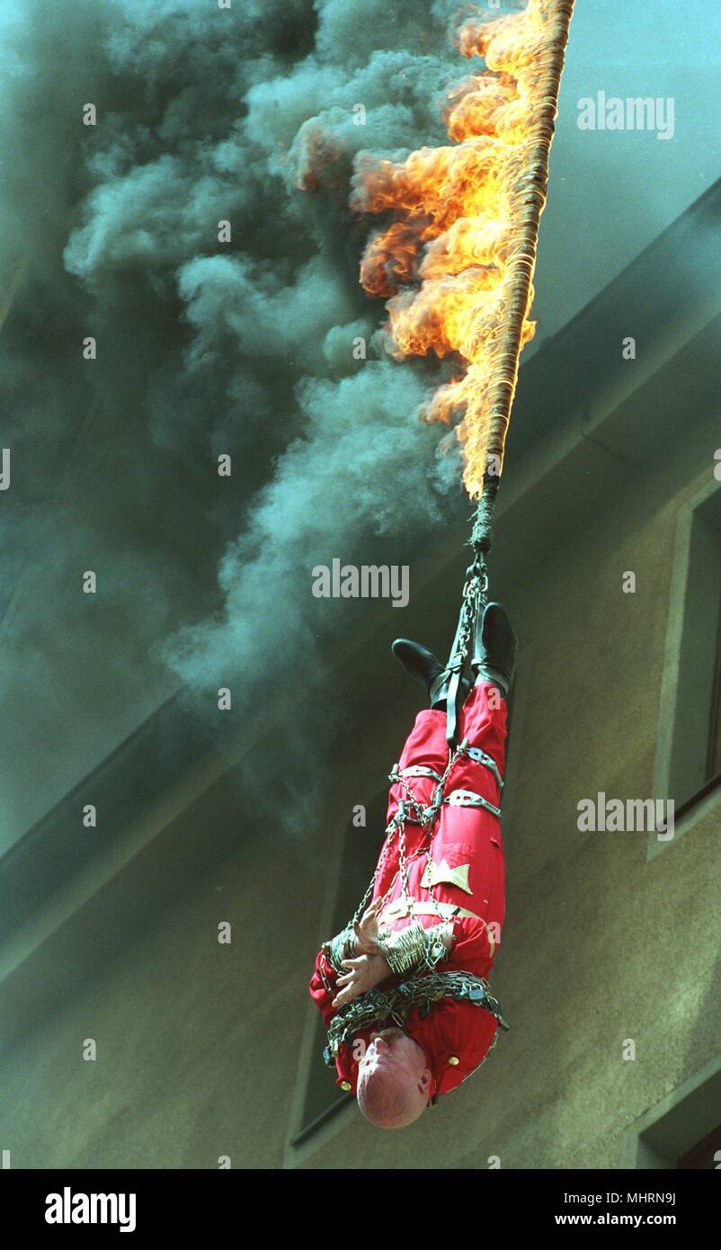 Hans Moretti est suspendu à la combustion la corde de chanvre. Seulement 27 secondes lui a laissé à libérer sans outils ou Hilfswithtel et ainsi sauver sa vie. Le 65-year-old acrobat avait été enchaîné à une grue par des officiers de police de haut-tête à une hauteur de 20 mètres. Alors la seule quatre centimètres de longueur de corde de chanvre a été déclenché et le déchaînement audacieuse loi pourrait commencer . La manifestation du 27/6/95 doit attirer l'attention sur l'ouverture prochaine de l'Varietetheater à Munchner Platzl en face de la Hofbrauhaus en septembre. Dans le monde d'utilisation | Banque D'Images