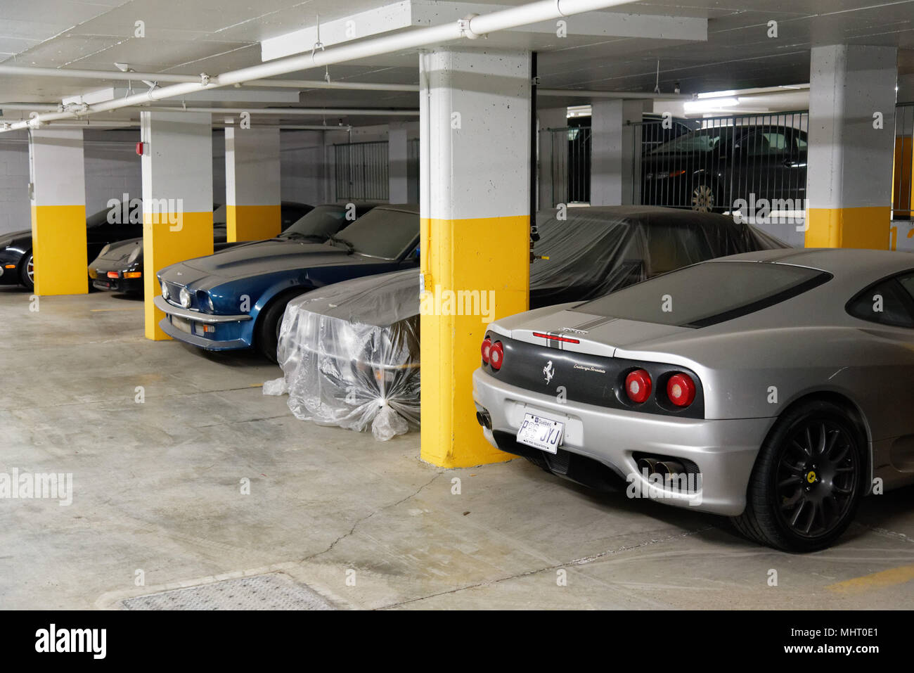 Cher les voitures de luxe dans un parc de stationnement souterrain à Montréal au Québec. Elles sont couvertes de poussière qu'ils n'ont pas été utilisés dans les dernières années. Banque D'Images