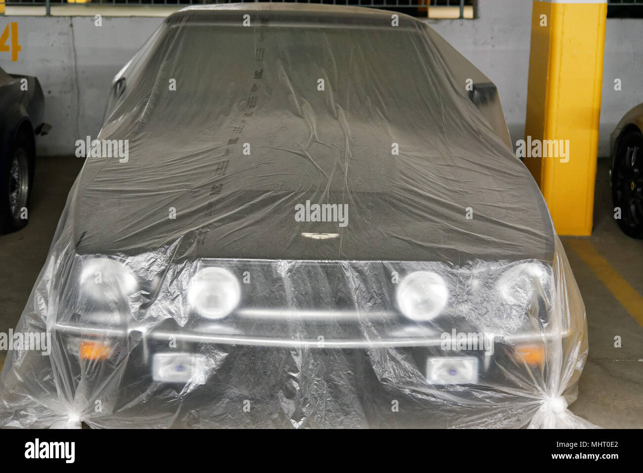 Cher les voitures de luxe dans un parc de stationnement souterrain à Montréal au Québec. Elles sont couvertes de poussière qu'ils n'ont pas été utilisés dans les dernières années. Banque D'Images