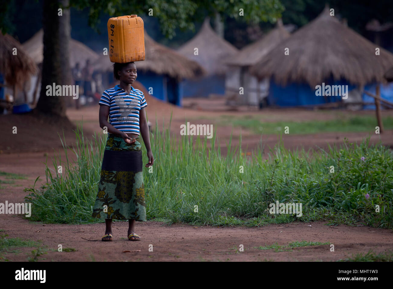 Une femme déplacée par les conflits armés transporte l'eau dans un camp pour personnes déplacées en Riimenze, au Soudan du Sud. Banque D'Images