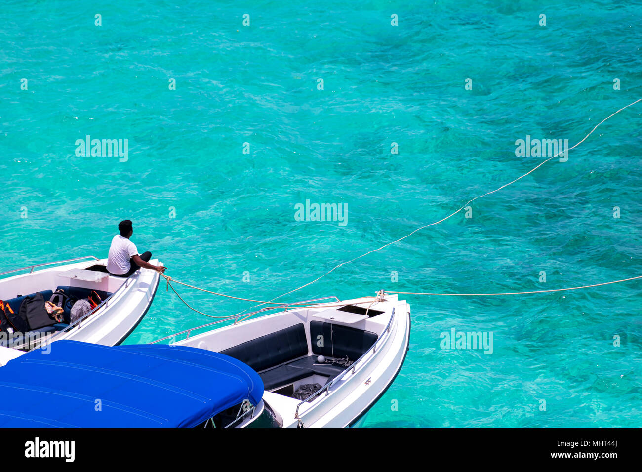 Vitesse 2--bateau stationné dans la mer.Le bateau paraît blanche et a un toit bleu.La mer bleu clair, réflexion de la lumière, les petites vagues. Banque D'Images