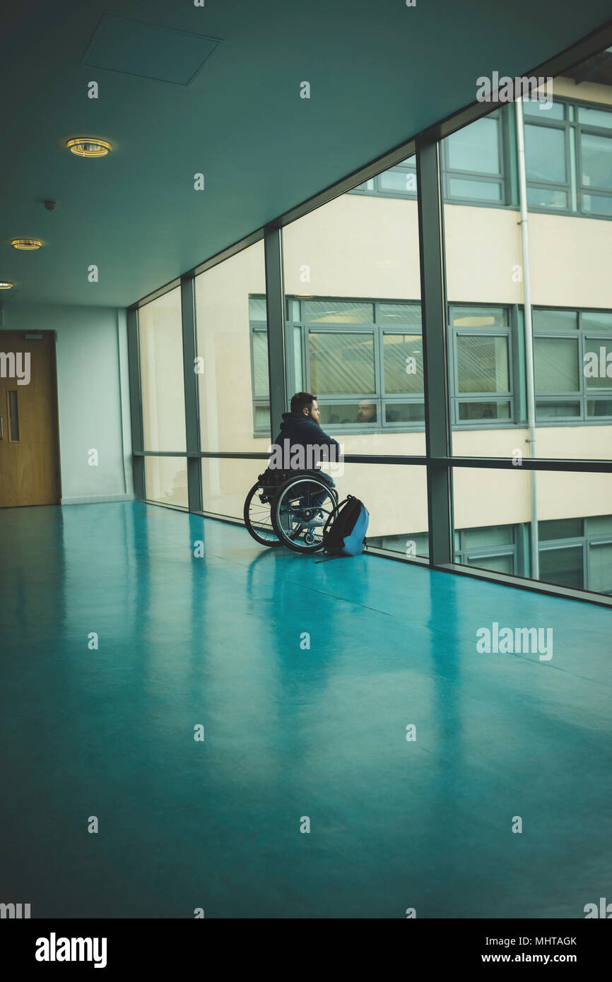 Homme handicapé sur fauteuil roulant à partir de panneau de verre Banque D'Images