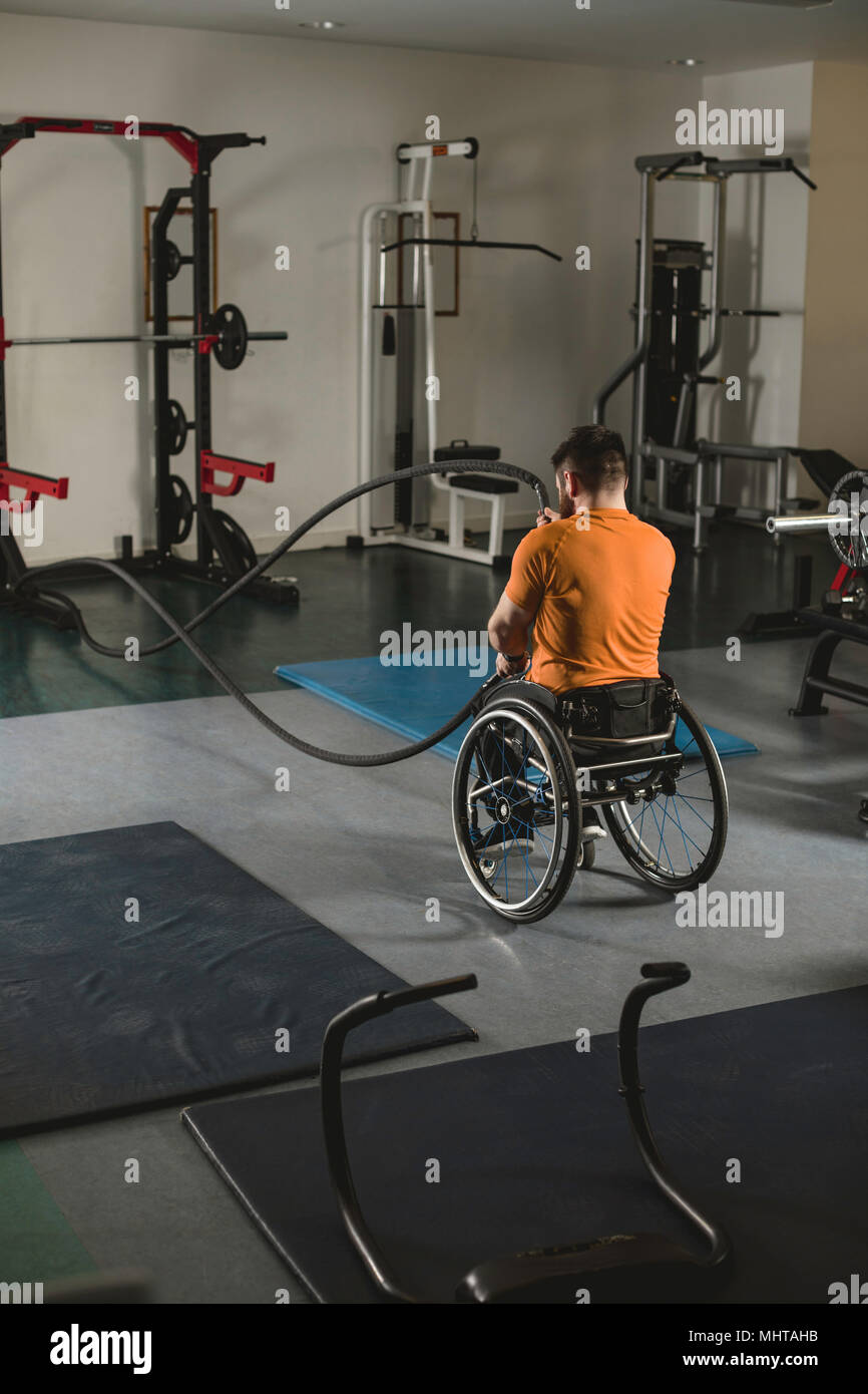 Homme handicapé en fauteuil roulant sur l'exercice de combat avec des cordes Banque D'Images